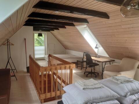 瓦埃勒Byhus Vejle的一间房子内带两张床和一张书桌的房间