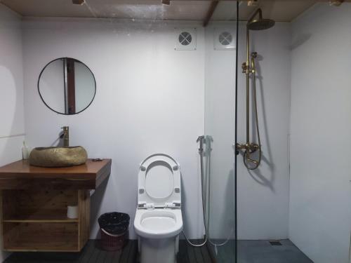木州县Flourish Homestay的一间带卫生间和玻璃淋浴间的浴室