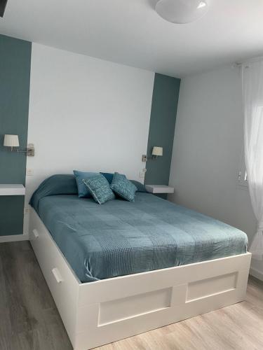 英格兰海滩Villa Clau的一间卧室配有一张带蓝色枕头的大床