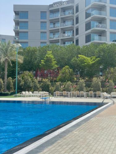 迪拜MAG 565, Boulevard, Dubai South, Dubai的一座高楼前的游泳池