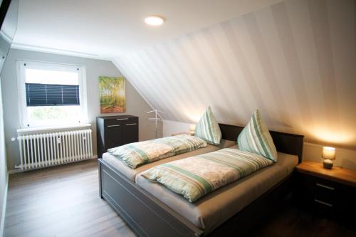 巴特萨克萨Ferienwohnung Ravensberg Dachgeschoss的一张床上有两个枕头的房间