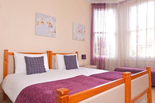 伊斯特布恩Cavendish apartment - central and spacious的一间卧室配有一张大床和紫色毯子