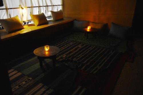 塔鲁丹特Riad Anma的一间设有两张桌子和一张带蜡烛的床的黑暗客房