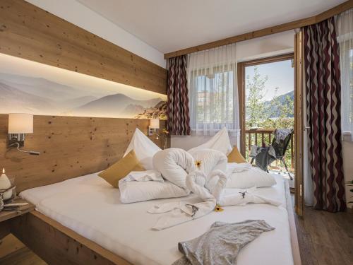 迈尔霍芬Apart Central – Premium Mountain&Garden的卧室配有带白色枕头的大床