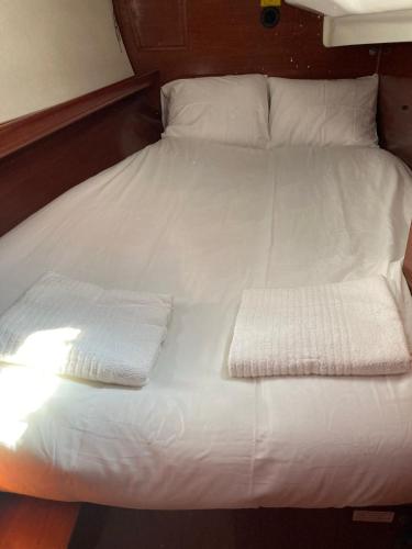 里斯本Sea Bloom - Sleep & Sail in Tejo的一张白色的床,上面有两张折叠毛巾