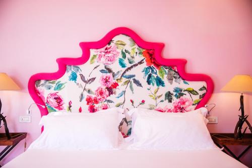圣安格塔苏德格尔夫顿阿尔丰索1890精品酒店的粉红色的卧室配有白色的床和花卉床头板