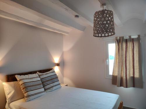 圣海梅-德恩韦哈Mas Midó的卧室配有白色的床和窗户。