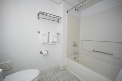 博林Greenwoods inn & Suites的白色的浴室设有卫生间和浴缸。