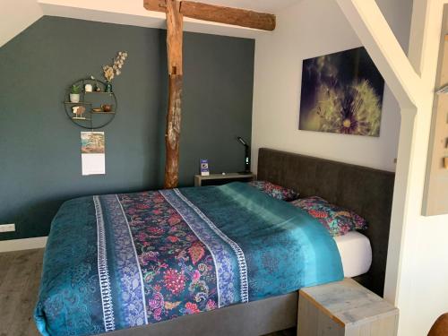 SinderenGastenverblijf 't Oelengoor的一间卧室配有一张带蓝色棉被的床