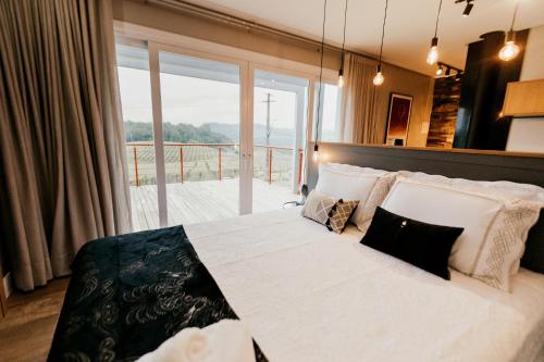 本图贡萨尔维斯Vista Vigneti Albergo & Vino - Vale dos Vinhedos的一间卧室设有一张大床和大窗户