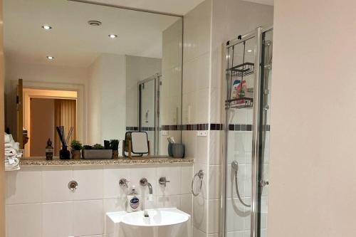 伯明翰Two-Bedroom Luxury Apartment with Workspace, Free Parking & coffee的白色的浴室设有水槽和淋浴。