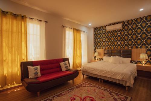 Lower Princeʼs QuarterJuly AirBnB的一间卧室配有一张床和一张红色的沙发