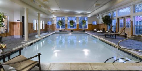 伯灵顿绿山套房酒店的酒店的大型游泳池配有桌椅