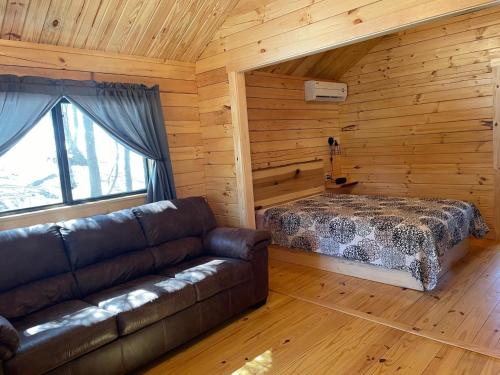 BarnesvilleLakewood Park Campground - Luxury Cabin的小木屋内的客厅配有沙发和床