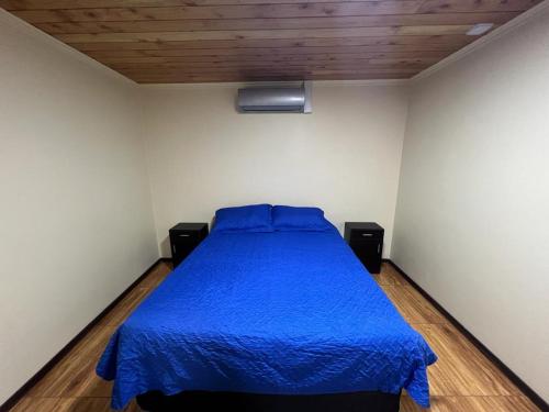 Santa BárbaraHospedaje Santa Barbara的一间卧室配有一张带蓝色床罩的床