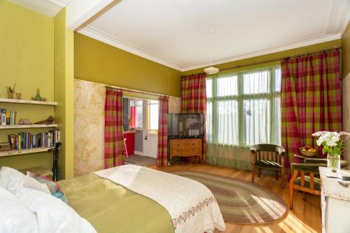 奥玛鲁Braemar House的一间卧室配有一张床、一张桌子和一台电视。