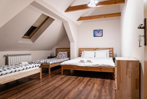CisiecDom Wypoczynkowy - Alexander的配有白色墙壁和木地板的客房内的两张床