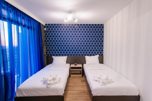 MiladinowziПиргуля的配有两张蓝色和白色壁纸的床铺
