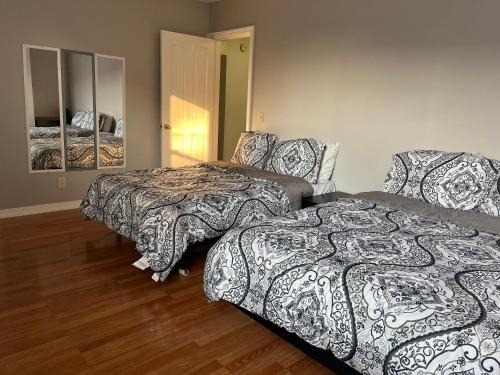 林登Lovely three Bedroom Apartment near Jersey city and Newyork的一间卧室配有两张床和镜子