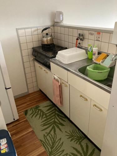 鹿儿岛短期賃貸ビッグバーンズマンション田上的厨房配有水槽和台面