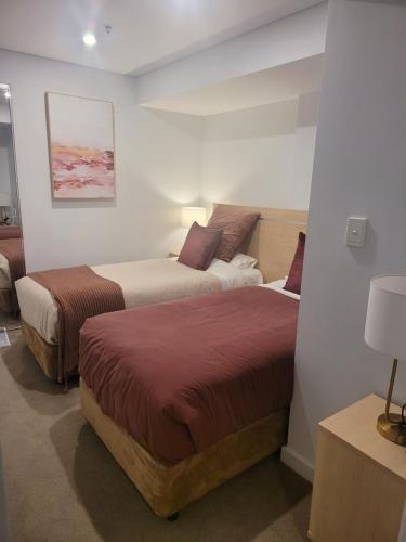 阿德莱德CBD Deluxe Private 2 Bedroom Apartment的配有两张床的酒店客房中的两张床