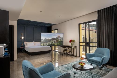 海法Hotel Botanica- Limited Edition By Fattal的酒店客房设有床和椅子以及起居室。