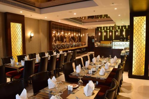利雅德富尔山贝斯特韦斯特优质酒店的一间带桌椅的餐厅和一间酒吧
