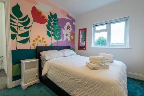 布里斯托3 bedroom home and garden in North Bristol的一间卧室设有一张床和鲜花墙