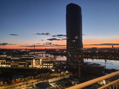 贝尔格莱德Belgrade Waterfront - Beograd na vodi的一座高楼,在晚上可欣赏到城市美景