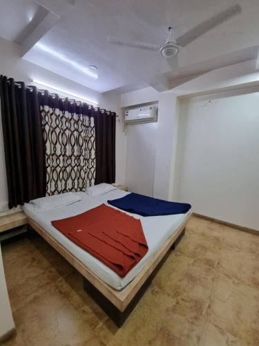 纳西克Sai Anand的一间卧室配有一张带红色和蓝色毯子的床
