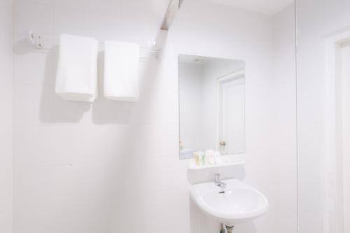 金边金边诚酒店的白色的浴室设有水槽和镜子