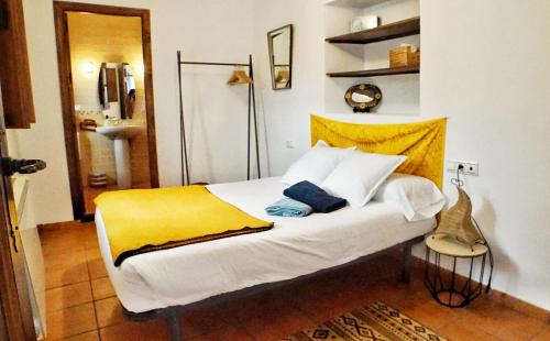 格拉纳达Entre Dos Aguas的卧室配有白色床和黄色毯子