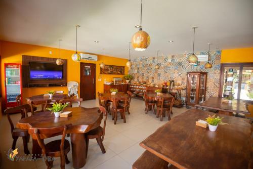 雅帕拉廷加Pousada Yapara-Tyba的一间设有木桌和椅子的餐厅