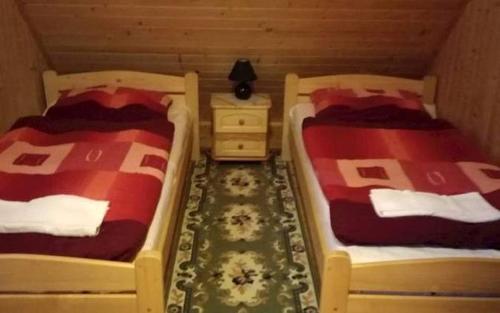 HruštínChata U Juraja的配有床头柜和两张sidx单人床的客房内的两张床