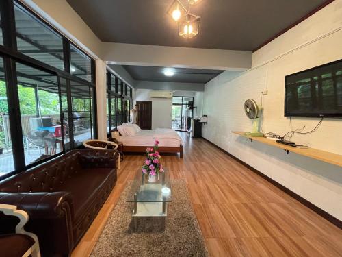 南邦Service Apartment ชั้น1ใจกลางเมืองใกล้แหล่งท่องเที่ยว的客厅配有沙发和1张床