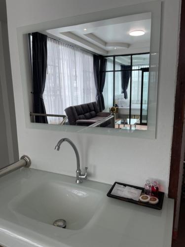 南邦Service Apartment ใจกลางเมืองใกล้แหล่งท่องเที่ยว119ทับ1ถนนปงสนุก的客厅水槽上方的镜子