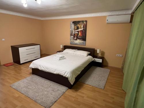 蒂米什瓦拉CASA DON的一间卧室配有一张带白色床单的床和梳妆台。