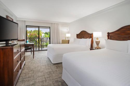 卫斯理堂Saddlebrook Golf Resort & Spa Tampa North-Wesley Chapel的酒店客房设有两张床和一台平面电视。