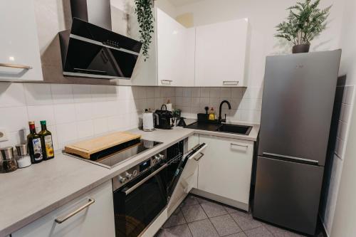 莱比锡Stilvolle, gemütliche Wohnung mitten im ZENTRUM的厨房配有白色橱柜和不锈钢冰箱