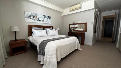 开普敦Canal Quays 507的卧室配有一张白色大床和镜子