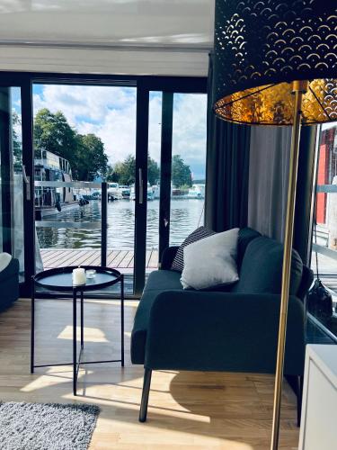 菲尔斯滕贝格Waterview - Schwimmendes Ferienhaus auf dem Wasser mit Blick zur Havel, inkl Motorboot zur Nutzung的带沙发的客厅,享有水景