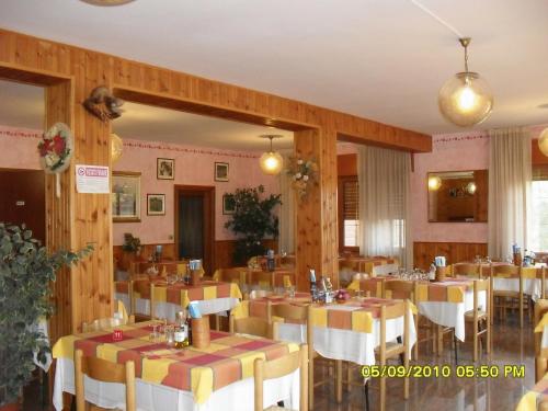圣奇诺·迪·蒙塔尼亚蒙塔巴尔迪那酒店的一间在房间内配有桌椅的餐厅