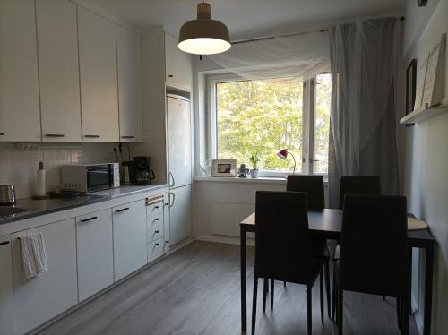 赫尔辛基Ihan Puotilan Metron lähellä的厨房配有桌椅和窗户。