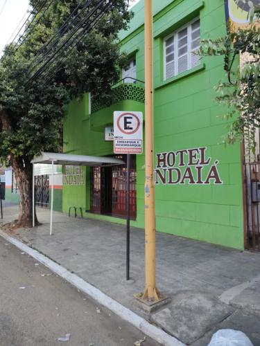 瓦拉达里斯州长市Hotel Indaiá的绿色建筑前的酒店印地亚标志