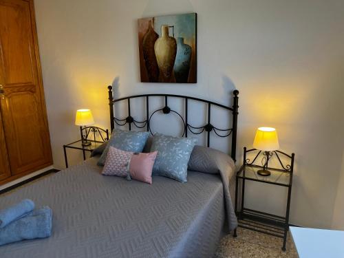 Playa del BurreroSarah Kite II Vv, Room 1的一间卧室配有一张带枕头的床和两盏灯。