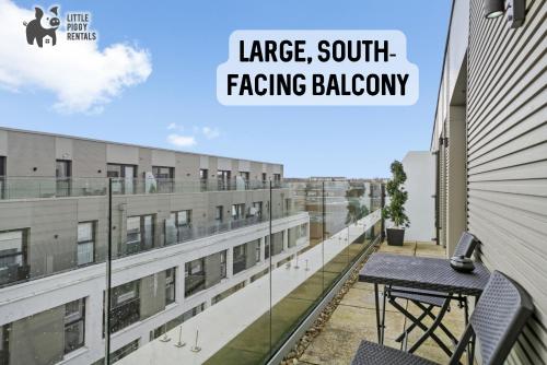 斯蒂夫尼奇Lux Penthouse Flat in Stevenage with Balcony, Super King Bed & Fast WiFi的阳台配有桌子,大楼设有朝南的大阳台