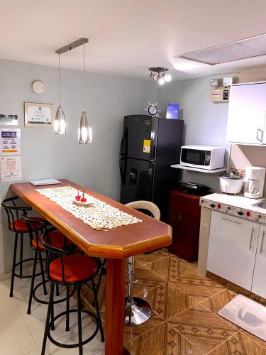 圣安德烈斯Apartment Angeluz的厨房配有木桌和冰箱。
