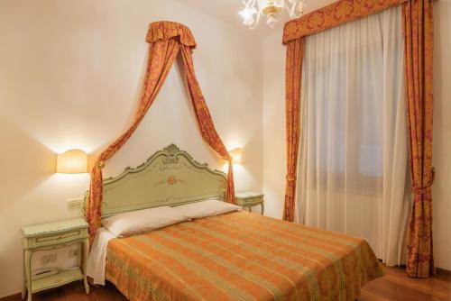 威尼斯Hotel al Sotoportego的一间卧室配有一张带橙色床罩的床