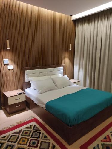 Sheikh ZayedLuxury Stay的一间卧室设有一张带木墙的大床