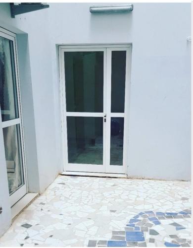 达喀尔JADO House的白色建筑的开放式门,铺着瓷砖地板